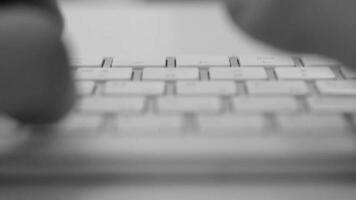 Business person types on a laptop keyboard. Type background. Modern office worker using a laptop, typing a text black and white footage video