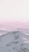 A snowy mountain range against a pink sky video