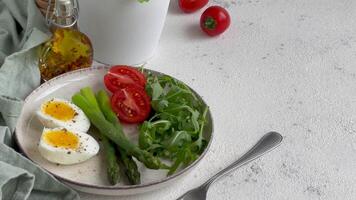 Frais printemps salade avec bouilli œufs, asperges, et tomates sur une brillant journée video
