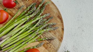 Fresh green asparagus lies on a wooden cutting board video