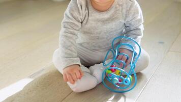 Cute baby girl playing with educational toy in nursery video