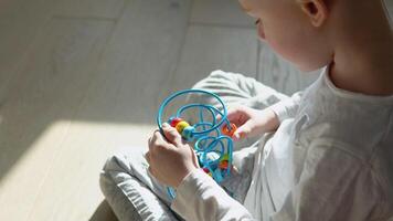 Little boy playing education logical toy on the floor in nursery video