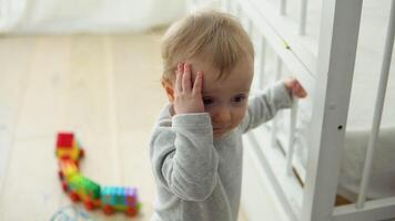 Baby nehmen zuerst Schritte in der Nähe von das Bett. wenig Mädchen Lernen zu gehen video