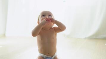 schattig glimlachen kind in luier spelen Aan de verdieping in kinderkamer video