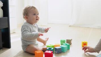 niño jugando con vistoso juguete bloques con madre. niños jugar. educativo juego para bebé y niñito video