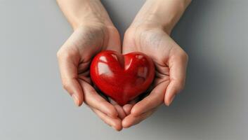 Person Holding Red Heart in Hands photo