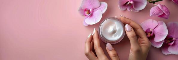 Womans Hands Holding Jar of Cream by Pink Flowers photo