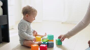 Child playing with colorful toy blocks with mother. Kids play. Educational game for baby and toddler video