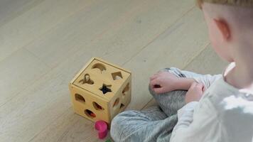 Two kids boy and girl playing with wooden shape sorter video