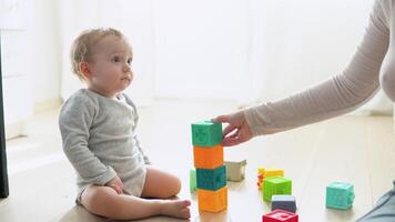 niño jugando con vistoso juguete bloques con madre. niños jugar. educativo juego para bebé y niñito video