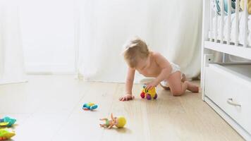 Smiling crawling cute baby in diaper at home on floor video