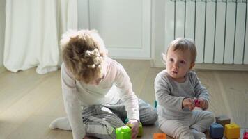 dos niños jugando con vistoso juguete bloques niños jugar. educativo juego para bebé y niñito video