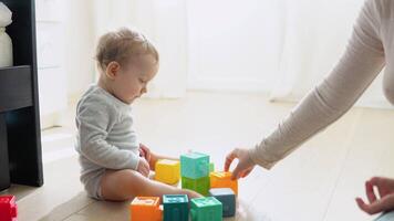 bambino giocando con colorato giocattolo blocchi con madre. bambini giocare a. educativo gioco per bambino e bambino piccolo video