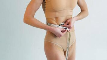 Sport girl measuring waist with measuring tape, reducing excess weight video