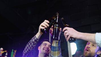 grupp av Lycklig vänner har roligt tillsammans, dricka flaska öl i en bar, firar, lyckligt leende - vänskap, samhörighet begrepp video