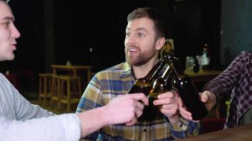 grupo de contento joven hombres Bebiendo frío sequía cerveza, chateando y teniendo bueno hora a pub. sonriente despreocupado amigos disfrutando Bebiendo juntos en bar video