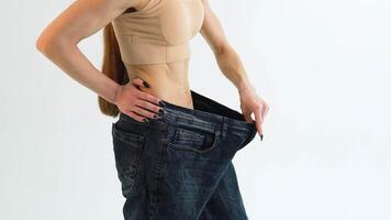 kvinna i oversize jeans efter vikt förlust, diet begrepp video