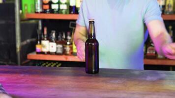 Barman opens two bottles of beer in interior of modern pub. Serve customers at bar video