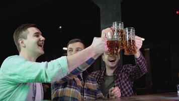 grupo de contento joven hombres Bebiendo frío sequía cerveza, chateando y teniendo bueno hora a pub. sonriente despreocupado amigos disfrutando Bebiendo juntos en bar video