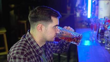 retrato do uma bonito caucasiano jovem homem bebendo saboroso dourado refrescante Cerveja bebida dentro uma bar video