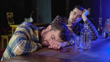 Two very drunken men in a bar pub, one of them sleeps on a table video