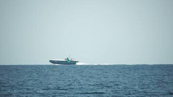 un alto velocidad barco es navegación en el calma océano. video