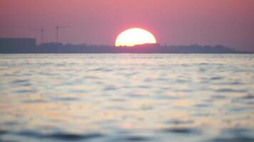 Sonnenuntergang Meer und Silhouette von Resort Stadt, Dorf gelegen auf das Strand mit rot Sonnenuntergang Sonne hinter. Urlaub Erholung Konzept. abstrakt nautisch Sommer- Ozean Sonnenuntergang Natur Hintergrund. video