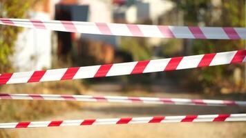 Red and white warning tape swinging in the wind. Protection sign. Don't cross the line. Red White caution tape pole fencing is protects for No entry. Backdrop without people, empty street. video