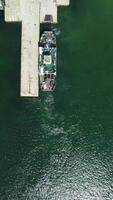 Ferry carrying cars and passengers across the sea, top down aerial drone view. Aerial vertical view on Ferry on the lake, transporting cars. deck of a boat carrying vehicles. video