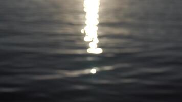 Sea water surface sunset. Low angle view over golden sea water. Sun glare. Abstract nautical summer ocean nature. Holiday, vacation and travel concept. Nobody. Slow motion. Weather and climate change video