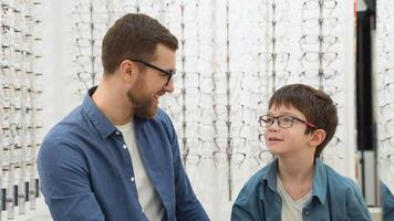 Little boy with his father in optics store. Ophthalmology concept video