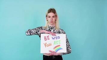 Attractive blond transgender caucasian man holding a protest sign during a LGBT pride parade. Love is love video