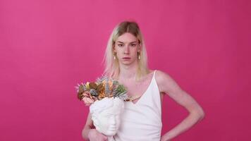 Transgender man with flowers against pink background video