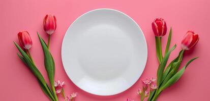 White Plate With Pink Tulips on Pink Background photo