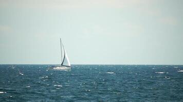 jacht Aan zee. luxe reis reis. kant visie van wit boot Aan diep blauw water. antenne visie van rijk jacht het zeilen zee. zomer reis Aan luxe schip. video