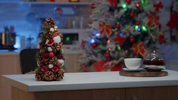 leeren Küche dekoriert mit Weihnachten Ornamente zum festlich Feier. Topf und Tasse von Tee platziert auf Holz Schalter. saisonal Dekorationen im Hintergrund zu genießen traditionell Veranstaltung video