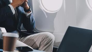 Side view portrait of handsome bearded businessman working while enjoying flight in first class, copy space video