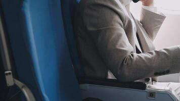 Side view portrait of handsome bearded businessman working while enjoying flight in first class, copy space video