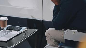 Side view portrait of handsome bearded businessman working while enjoying flight in first class, copy space video