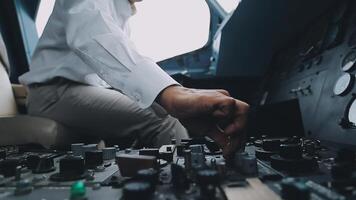 The pilot presses the power buttons on the control panel to control the aircraft in front of cockpit windshield video