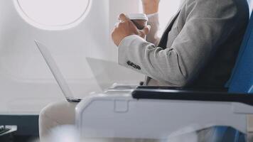 Side view portrait of handsome bearded businessman working while enjoying flight in first class, copy space video