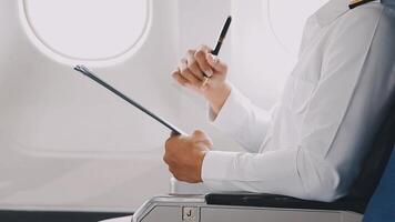 Side view portrait of handsome bearded businessman working while enjoying flight in first class, copy space video