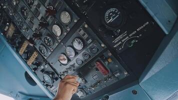 The pilot presses the power buttons on the control panel to control the aircraft in front of cockpit windshield video