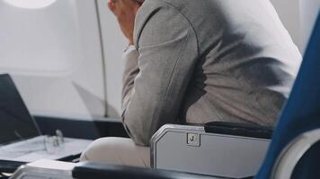 lado Visão retrato do bonito barbudo homem de negocios trabalhando enquanto desfrutando voar dentro primeiro aula, cópia de espaço video