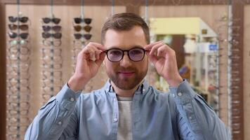 Man in a glasses. Guy in a optics shop. Ophthalmology, excellent vision or optician shop concept. Laser surgery alternative video