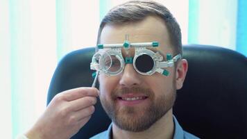 un hermoso masculino paciente vistiendo especial oftálmico lentes. médico cheques visión a el paciente video