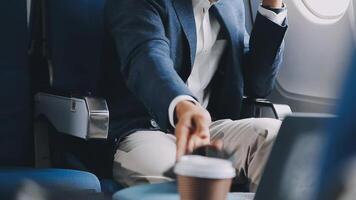 Side view portrait of handsome bearded businessman working while enjoying flight in first class, copy space video