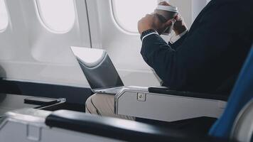 Side view portrait of handsome bearded businessman working while enjoying flight in first class, copy space video