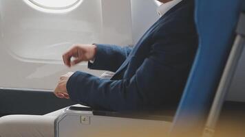 Side view portrait of handsome bearded businessman working while enjoying flight in first class, copy space video