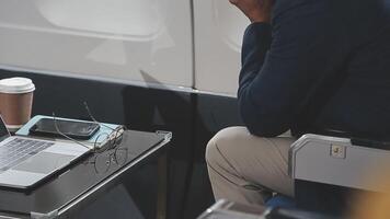 Side view portrait of handsome bearded businessman working while enjoying flight in first class, copy space video